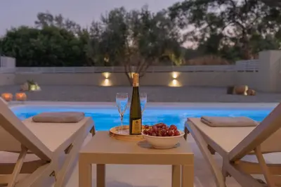 a table with a bottle of wine and a bowl of fruit at Casa Elia Filerimos in Pastida