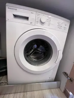 a white washing machine sitting in a room at Pavlos House in Symi