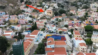 an aerial view of a town with a red arrow at Pavlos House in Symi
