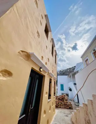 a building with a door in the side of it at Pavlos House in Symi
