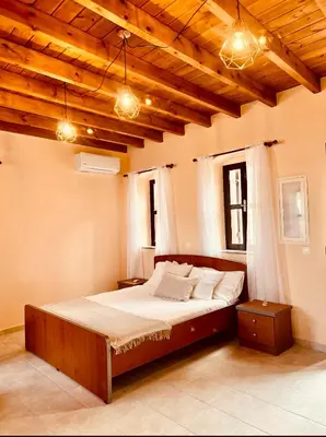 a large bed in a room with wooden ceilings at Pavlos House in Symi