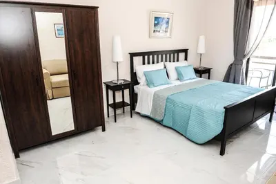 a bedroom with a bed with blue pillows and a mirror at Valentino Hotel in Kremasti