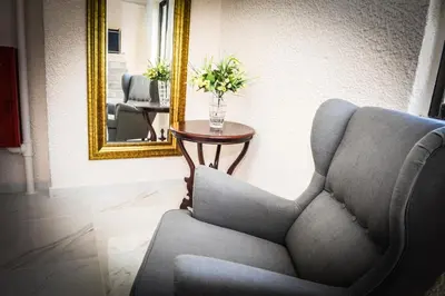 a living room with a chair and a mirror at Valentino Hotel in Kremasti