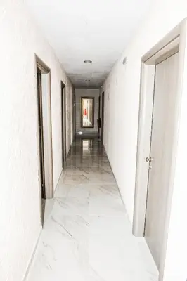 an empty corridor with white walls and white floors and a white door at Valentino Hotel in Kremasti