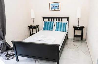 a bedroom with a black bed with blue and white pillows at Valentino Hotel in Kremasti