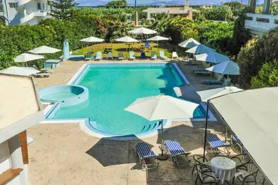 a swimming pool with umbrellas and chairs and a pool at Valentino Hotel in Kremasti