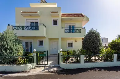 a white house with a fence in front of it at Hermione Villa in Gennadi