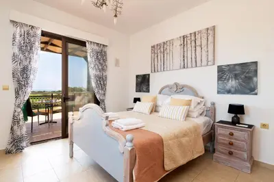 a bedroom with a bed and a balcony at Villa Alnika Acacia by Villa Plus in Lachania