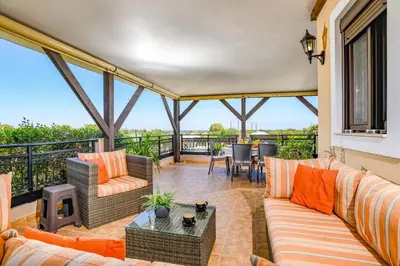 a screened in porch with couches and a table at Villa Alnika Acacia by Villa Plus in Lachania