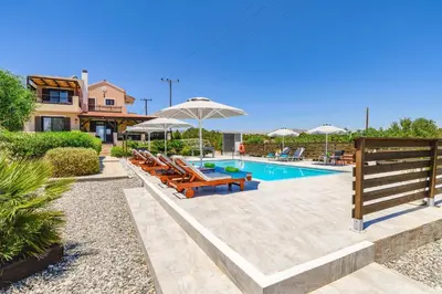 a swimming pool with lounge chairs and umbrellas at Villa Alnika Acacia by Villa Plus in Lachania