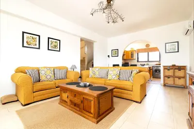 a living room with two couches and a coffee table at Villa Alnika Acacia by Villa Plus in Lachania