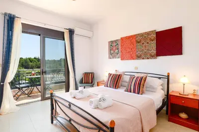 a bedroom with a bed with towels on it at Villa Alnika Azalea by Villa Plus in Lachania