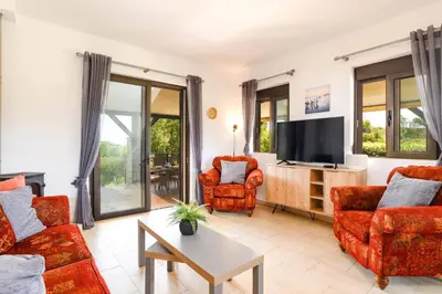 a living room with red furniture and a flat screen tv at Villa Alnika Azalea by Villa Plus in Lachania
