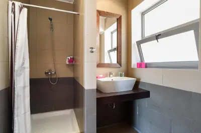 a bathroom with a sink and a shower and a mirror at Villa Anastasia Rodos by Villa Plus in Líndos