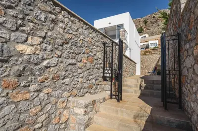 a stone wall with a staircase with wrought iron gates at Villa Anastasia Rodos by Villa Plus in Líndos