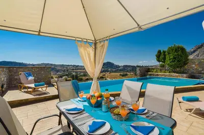 a patio with a table and a swimming pool at Villa Anastasia Rodos by Villa Plus in Líndos