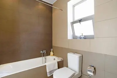 a bathroom with a toilet and a tub and a window at Villa Anastasia Rodos by Villa Plus in Líndos