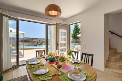 a dining room with a table with wine glasses at Villa Anastasia Rodos by Villa Plus in Líndos