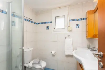 a bathroom with a toilet and a sink and a shower at Amphitrite Villa in Gennadi