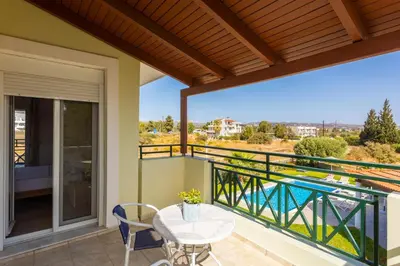 a patio with a table and chairs on a balcony at Amphitrite Villa in Gennadi