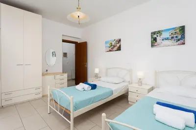 a bedroom with two beds and a mirror at Amphitrite Villa in Gennadi