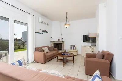 a living room with a couch and chairs and a fireplace at Amphitrite Villa in Gennadi
