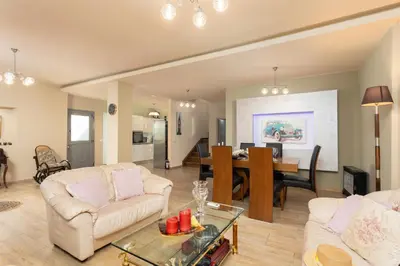 a living room with two white couches and a dining room at Villa Ammos in Afantou