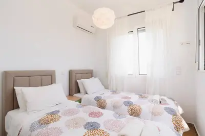 two beds in a bedroom with white walls at Villa Sophie Gennadi in Gennadi