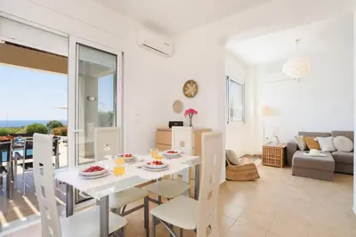 a dining room and living room with a table and chairs at Villa Sophie Gennadi in Gennadi