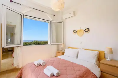 a bedroom with a bed and a large window at Villa Sophie Gennadi in Gennadi