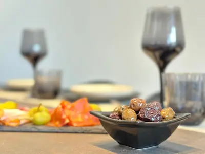 a bowl of fruit on a table with two wine glasses at Seaside Deluxe Apartment in Ialyssos