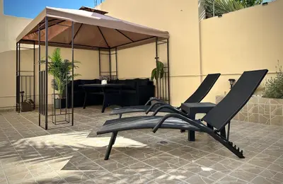 a pair of chairs sitting on a patio at Seaside Deluxe Apartment in Ialyssos