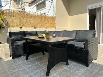 a table and chairs and a couch on a patio at Seaside Deluxe Apartment in Ialyssos