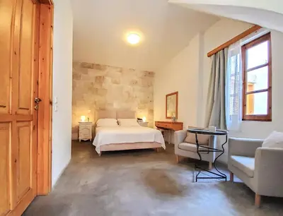 a bedroom with a bed and a table and a chair at St. George Studios in Rhodes Town