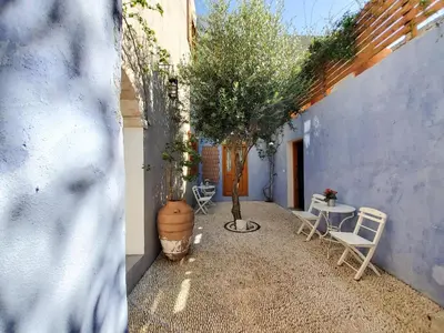 a patio with a table and chairs and a tree at St. George Studios in Rhodes Town
