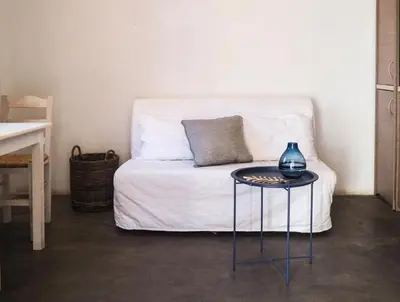 a room with a bed with a table with a vase on it at St. George Studios in Rhodes Town