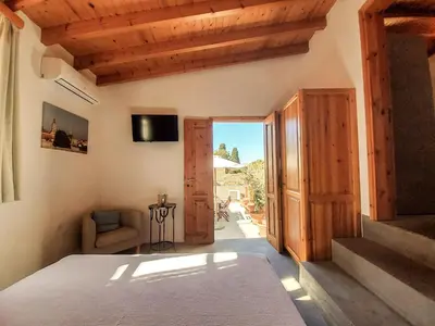a bedroom with a bed and a sliding glass door at St. George Studios in Rhodes Town