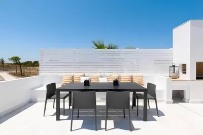 a black dining table and chairs on a patio at Seafish Villa, 2 Luxury Villas at Lachania Beach in Lachania