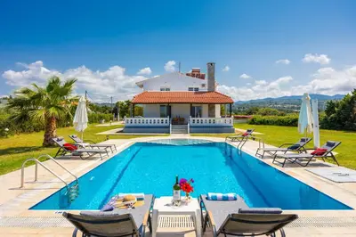 a villa with a swimming pool in front of a house at Villa Sunset Paradise in Kalavárda