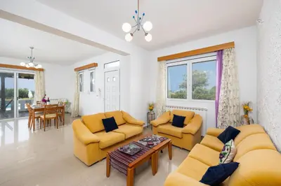 a living room with two couches and a table at Villa Sunset Paradise in Kalavárda