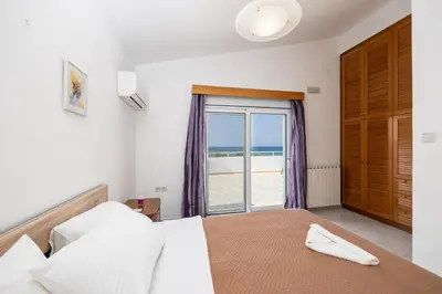a bedroom with a bed and a view of the ocean at Villa Sunset Paradise in Kalavárda