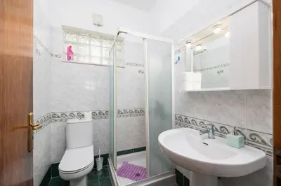 a bathroom with a toilet and a sink and a shower at Villa Sunset Paradise in Kalavárda