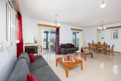 a living room with a couch and a table at Villa Sunset Paradise in Kalavárda
