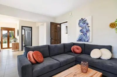 a living room with a gray couch with pillows on it at Villa Angelika Lindos by Villa Plus in Pefki Rhodes
