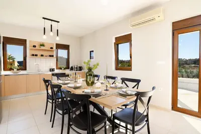 a kitchen and dining room with a table and chairs at Villa Angelika Lindos by Villa Plus in Pefki Rhodes