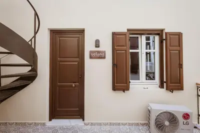a room with two doors and a window and a fan at Zerania Selana Studio in Rhodes Town