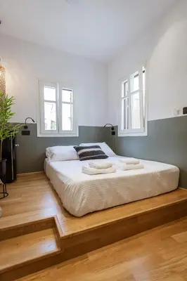 a large bed in a room with two windows at Zerania Selana Studio in Rhodes Town