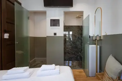 a bathroom with a shower with two towels on a bed at Zerania Selana Studio in Rhodes Town