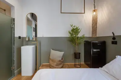 a bedroom with a white bed and a refrigerator at Zerania Selana Studio in Rhodes Town