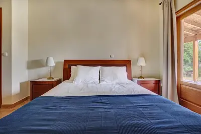 a bedroom with a large bed with a blue blanket at Villa Eremia in Pastida